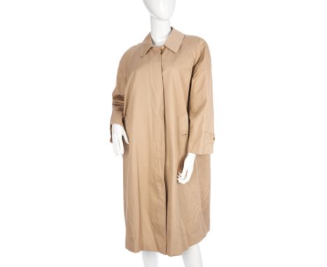 Burberry, a ladies trench overcoat, featuring a short collar, front button fastenings, hands through pockets and the maker's 