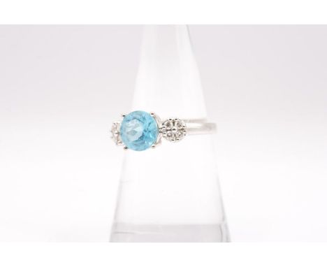 An electric blue Apatite and diamond dress ring in 18ct gold. Hallmarked for Birmingham and with an "Iliana" stamp. The centr