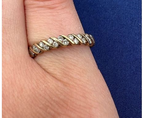 A 9ct gold diamond half hoop ring, containing 18 round brilliant cut diamonds. Total estimated diamond weight 0.25 carats.Siz