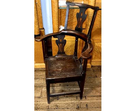 A George II elm corner chair, circa 1740, comb back top on urn shaped pierced splat, curve scrolled end armrests, square seat