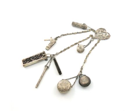 A late-Victorian silver chatelaine, various dates and makers, the heart-shaped mount, with pierced foliate and cherub decorat