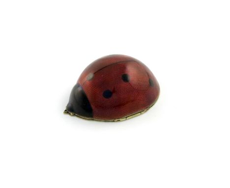 A gilt metalware-mounted enamel lady-bird box, unmarked, the red and black enamel body seven spots, the hinged cover with eng