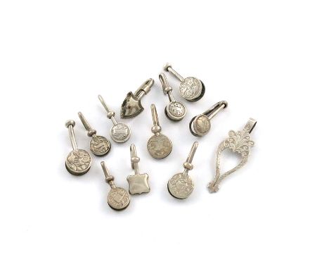 A collection of twelve silver napkin clips, various dates and makers, including one of shield form, one rectangular, nine of 