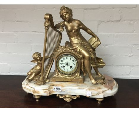 A French late 19th century mantel clock with gilded classical figures with a harp on a marble base. Hight 48cm