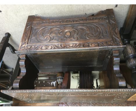 A oak carved monks bench The lift up seat above a foliage panel.