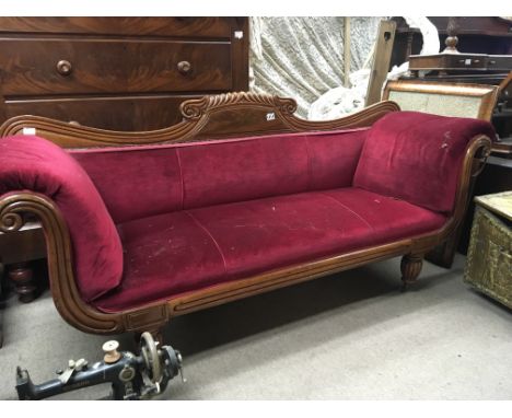 A Regency mahogany sofa with a shaped top rail and scroll ends on fluted legs.
