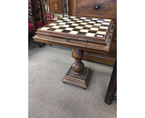 A chess table with a polished stone top above two drawers on a turned column. 58cm square NO Reserve