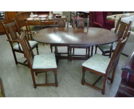 An Old Charm stained oak extending dining table, the oval top raised on carved, planked, lyre shaped ends, united by a stretc