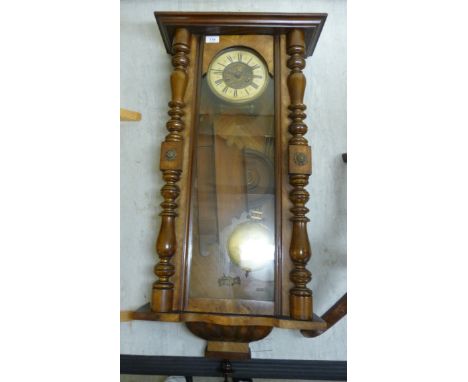 A late Victorian walnut cased Vienna regulator; the movement faced by a cream painted enamel Roman dial  40''h  19''w        