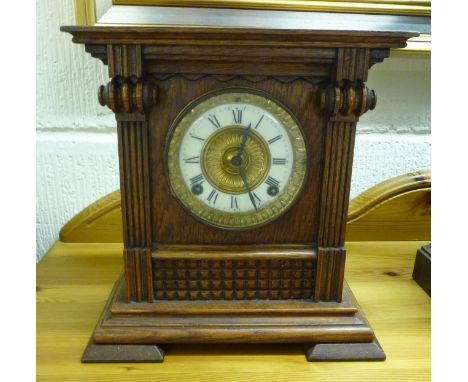 An early 20thC American, oak cased mantel clock with a platform top and scrolled flanks; the Ansonia gong strike movement fac