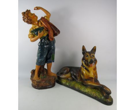 Two large vintage chalkware statues one of a boy eating a cherry and one of a Alsation. The tallest stands 26.5" (boy has a c