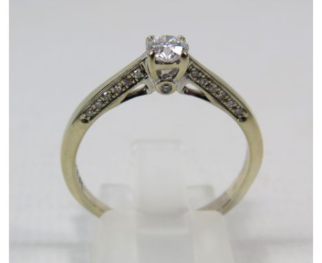 18ct White gold .40ct diamond solitaire ring with Accents to the inner shoulders, finger size R. 3.3 grams