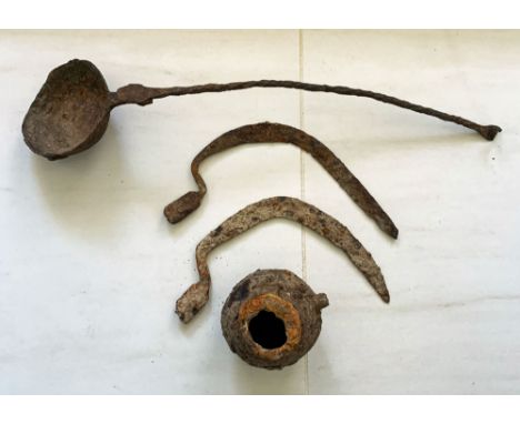 A group of four Roman iron objects. The first is a large ladle, 20-1/2 in. long, with a twisted handle, a pair of curved blad