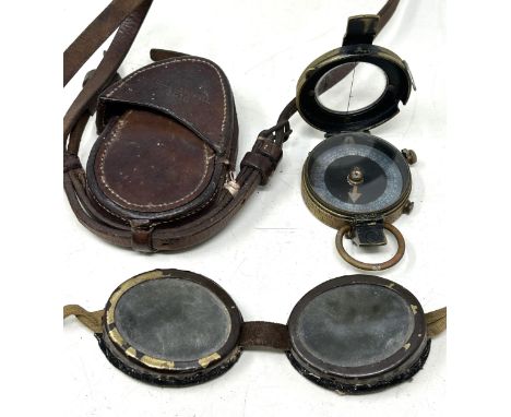 A WWI compass, 1918, in a leather Pulley & Powell 1916 leather case, and a pair of heavily tinted goggles 
