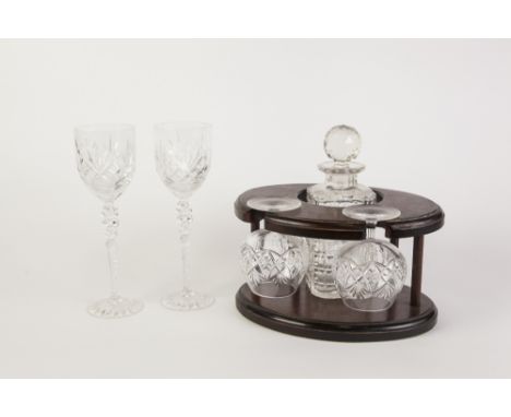 SET OF SIX CUT GLASS TALL HOCK GLASSES, on elaborate long tapering stems and star cut circular base, and a WOODEN STAND with 