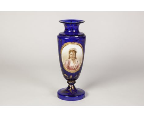 EARLY TWENTIETH CENTURY OVERLAID BLUE GLASS PEDESTAL VASE, of ovoid form with waisted neck, the gilt lined oval panel well pa