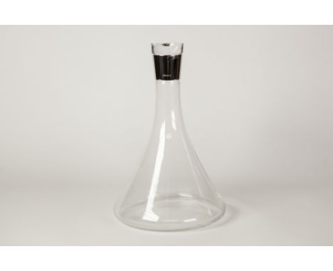 A MODERN CLEAR GLASS DECANTER OF SPREADING TAPERED DESIGN with glass stopper, the neck with plain white metal collar inscribe