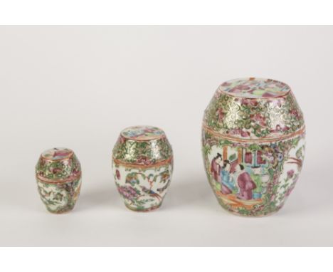 SET OF THREE LATE 19th CENTURY CHINESE CANTON DECORATED BARREL SHAPED COVERED JARS, autour with figural and floriated panels 
