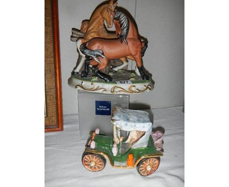 A pair of ceramic fighting horses and a ceramic car.
