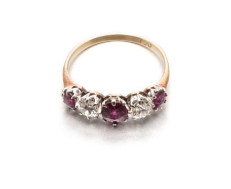 A RUBY AND DIAMOND RING centred with a claw-set oval mixed-cut ruby weighing approximately 0.38cts, flanked on either side by