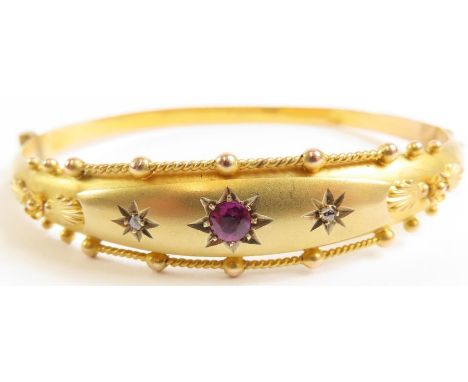 A 9 carat gold hinged bangle, the central panel set with a purple stone and two white stones, all star set, with a Chester ha