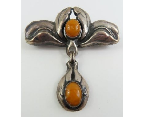 An Art Nouveau Bernhard Hertz brooch in the form of an iris, set with two oval cabochon cut yellow orange stones, marked to t