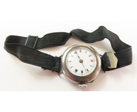 A silver WWI trench style wrist watch, the white enamel dial with black Roman numerals (red 12) and blue steeled hands, on fa