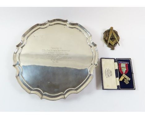 A silver salver, Sheffield 1910, of circular shaped outline, on four supports, inscribed with a Masonic presentation, 30.5 cm