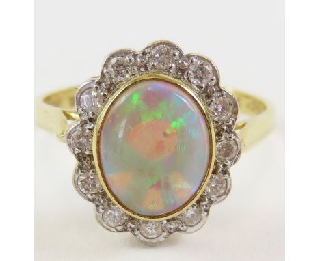 An 18ct gold opal and diamond cluster ring, the oval cabochon cut opal approximately 9mm x 7mm x 3.25mm, approximately 1.16ct