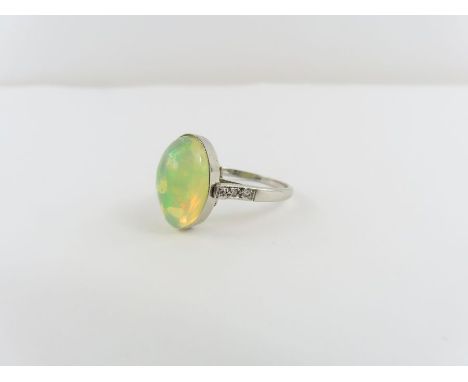 An opal ring, the mount stamped ‘Plat’, diamond set shoulders, the oval cabochon cut opal approximately 13.75mm x 9.75mm, fin