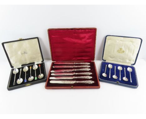 A cased set of six silver and enamel tea spoons, Walker &amp; Hall, Birmingham 1949; with another cased set of silver coffee 