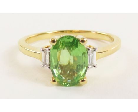 An 18ct gold tsavorite garnet and diamond ring, the oval garnet measuring approximately 8.7mm x 6.35mm x 3.35mm, approximatel