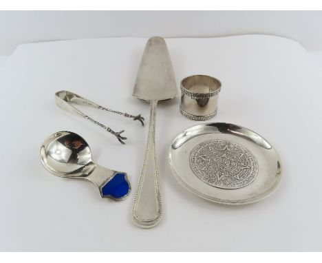 A silver napkin ring; a pair of silver claw sugar tongs; a Mexican silver dish with the mayan calendar; 98 g (3.1 troy ozs) g