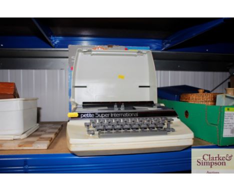 A petite Super International portable typewriter and original box 