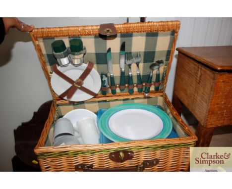 A wicker picnic hamper and contents