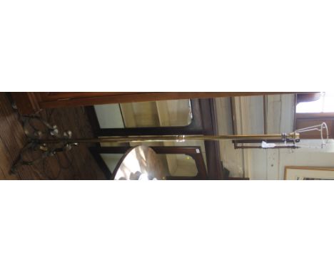 A mid-20th century brass floor lamp with circular turned column