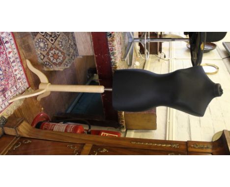 A female mannequin with nylon cover on a beech tripod stand