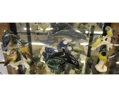 A Lladro figurine of two dolphins riding a wave, a similar Poole Pottery figurine of a dolphin and four other ceramic figurin