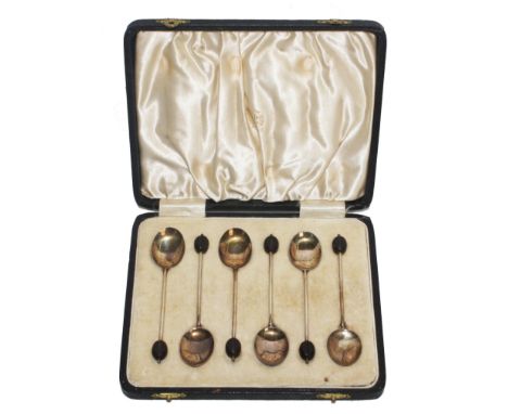 A cased set of silver and enamel coffee spoons, as found