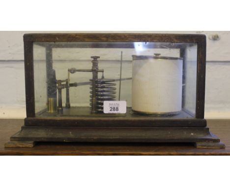 An early 20th century glass cased barometer of oblong form on a shaped plinth