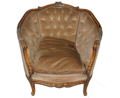 A 19th century-style French walnut framed armchair with profuse carving to the top rail and arm supports, button back fabric 