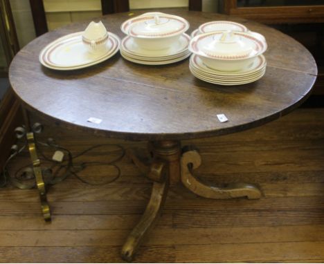 A 19th century oak circular centre table on a turned central column with 'C' scroll-shaped tripod support 66H x 107 cm W