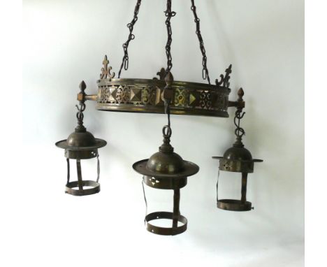 An Arts and Crafts brass hanging light
The central circular column having pierced decoration, above three hanging shades. 
