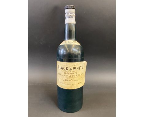 A novelty musical cigarette dispenser in the form of and advertising a Buchann's 'Black &amp; White' Scotch Whisky bottle, 11