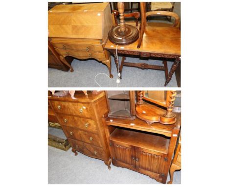 A 1950's walnut veneered four height chest of drawers, a linen fold carved oak low cabinet, a light oak bureau and a carved s