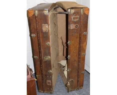 An early 20th century metal and wooden bound brown leather steamer trunk, with tan leather mounted corners