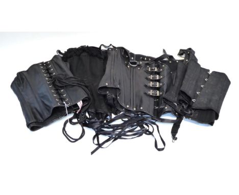 Four modern black lace-up corsets, comprising a leather example by Leatherotics, another leather example by Corsets Boulevard