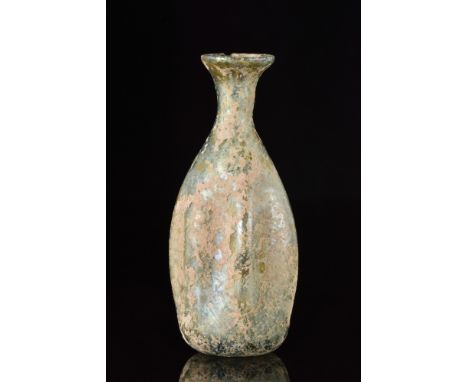 Ca. 100-200 AD. A blown glass flask, featuring a bulbous body with vertical indentations spaced in equal intervals, a cylindr