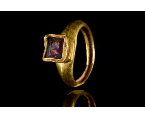 Ca. 400 AD. A gold finger ring comprising a round hoop with a slightly carinated profile, expanding shoulders, and a trumpet-