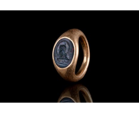 Ca. 300-400 AD. A possibly later gold ring with a hollow, round hoop widening to the shoulder; oval bezel set with jasper int